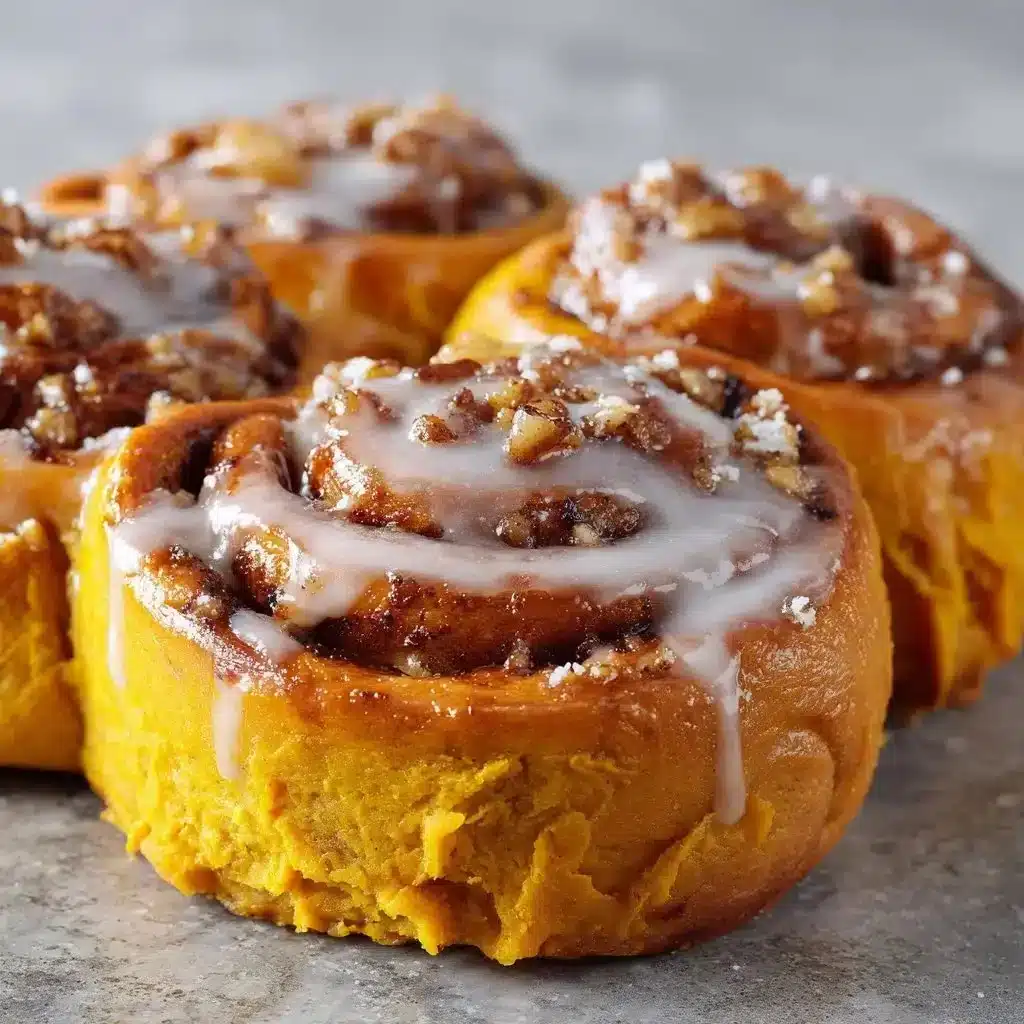 Heavenly Sweet Potato Cinnamon Rolls 3 Heavenly sweet potato cinnamon rolls topped with icing on a wooden table.
